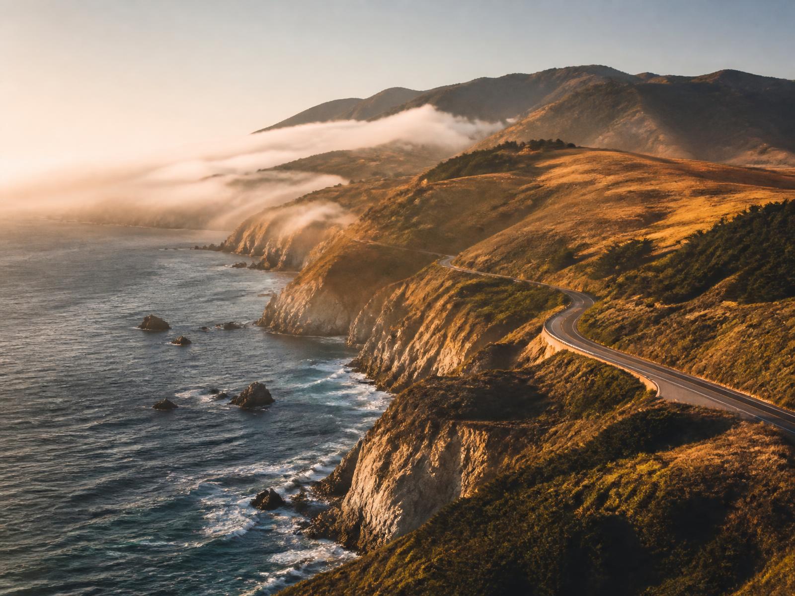Central California coastline with fog rolling over cliffs at sunset